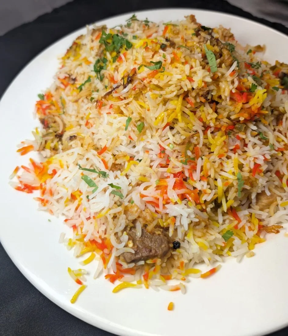 Dum Biryani — slow-layered saffron basmati with whole spices, halal chicken or goat, at Wok & Karahi, Spring TX